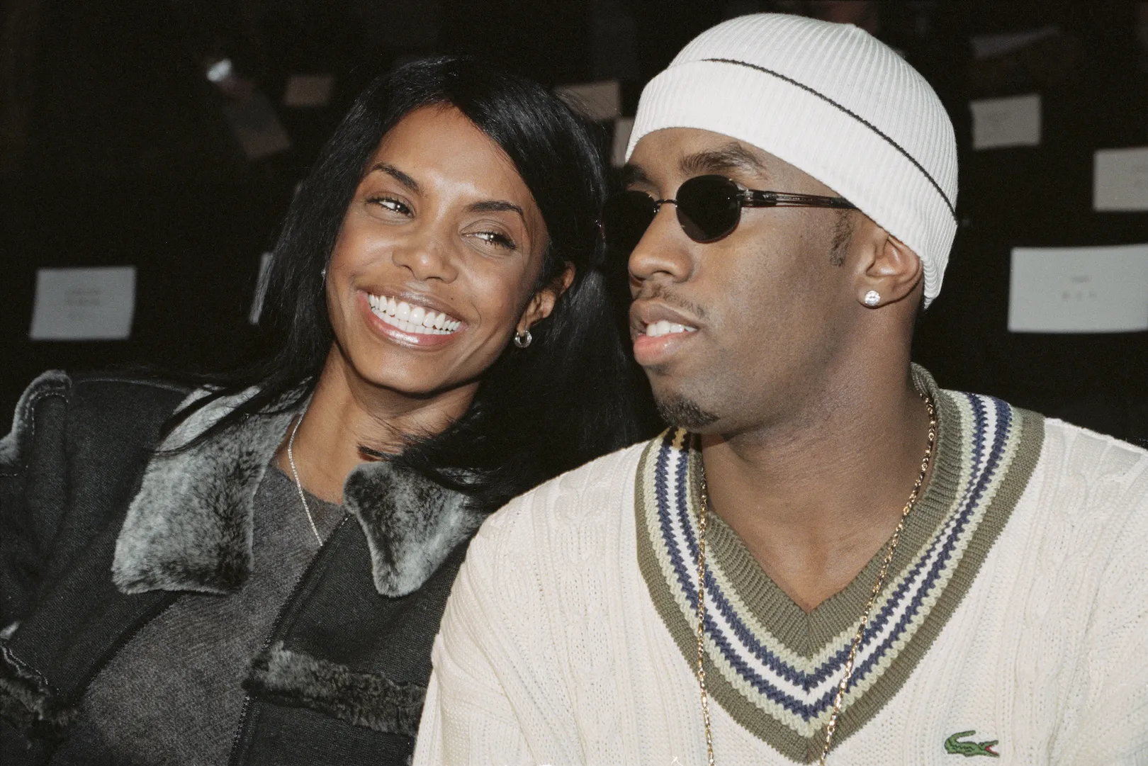 Kim Porter sitting next to Sean 'Diddy' Combs and smiling while looking at him.