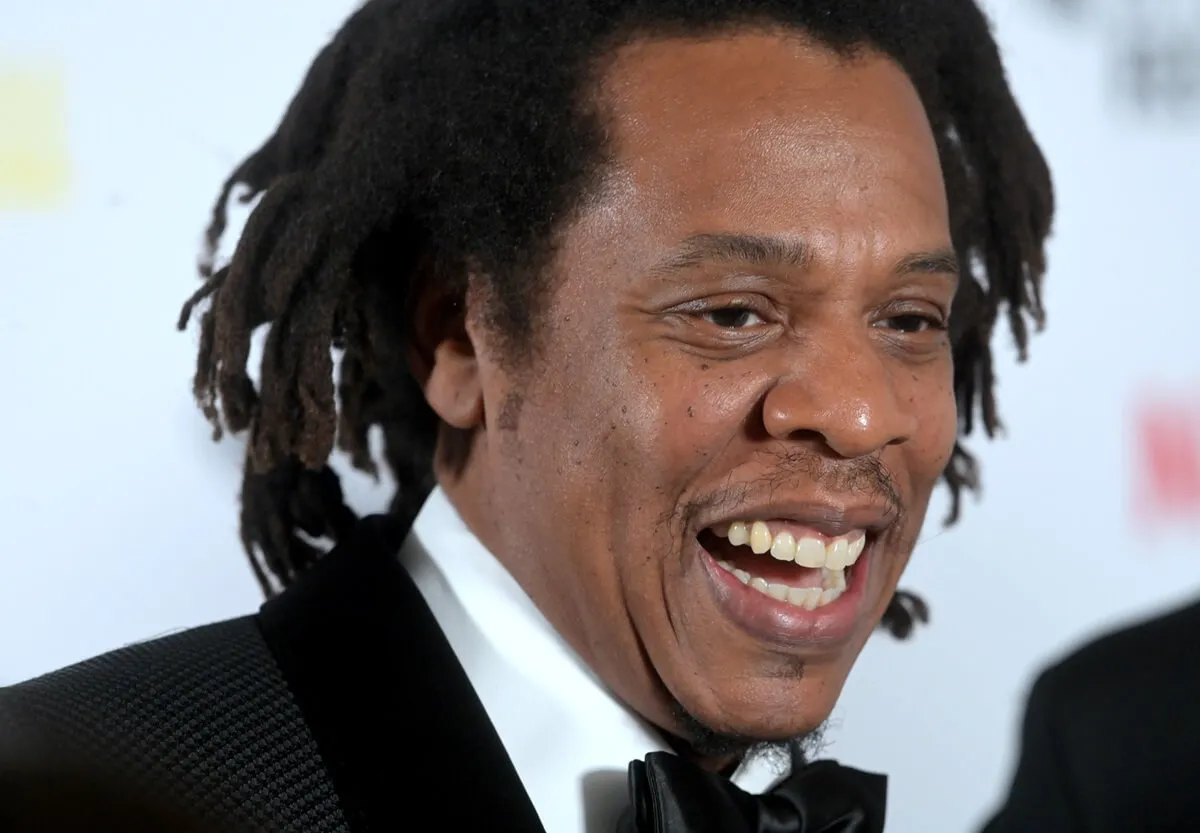 Jay-Z smiling at "The Harder They Fall" World Premiere in a suit.