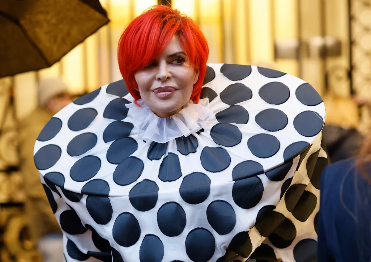 Wearing polka dots and an orange wig, Lisa Rinna peeks outside of the Viktor & Rolf fashion show in Paris