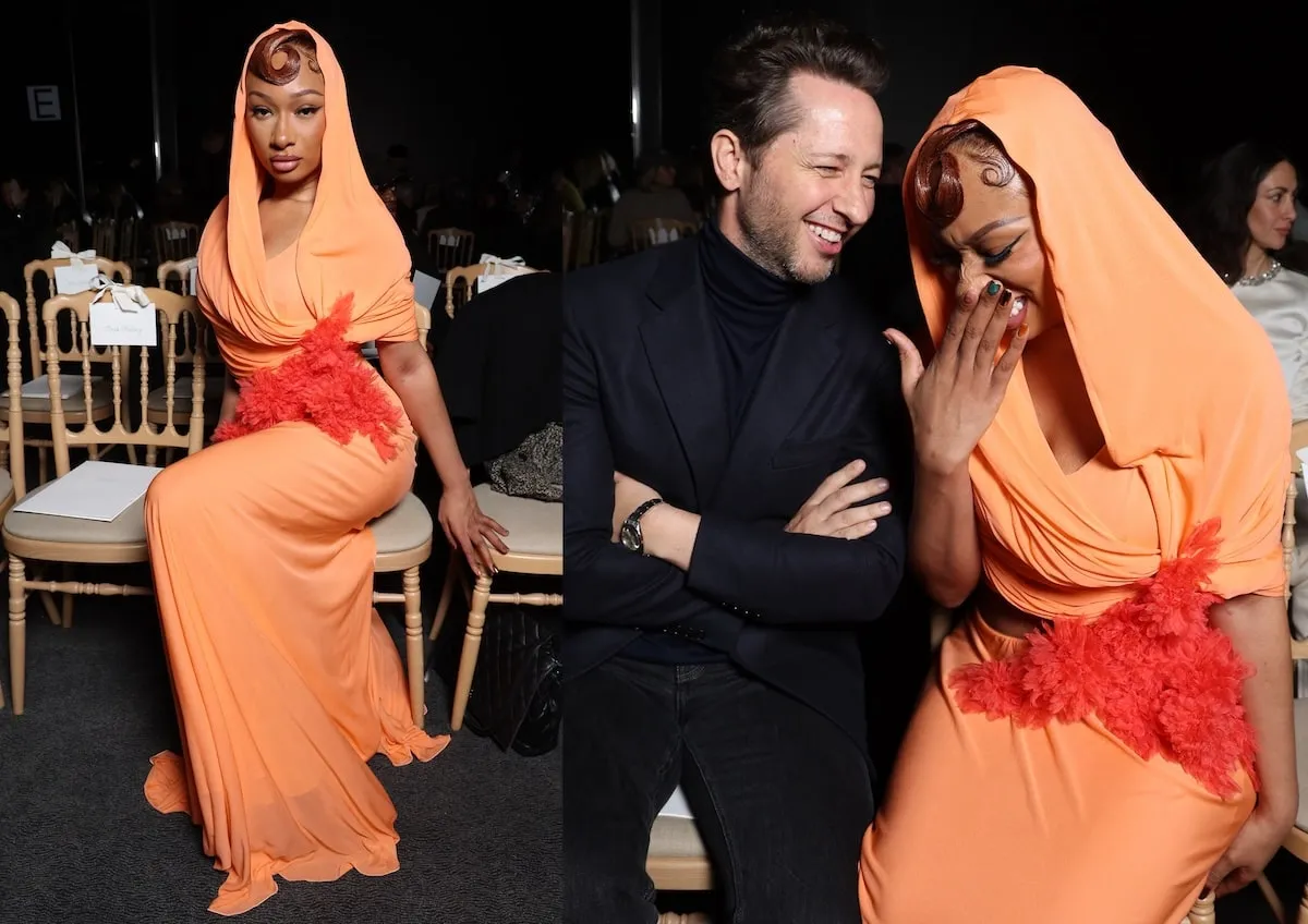 Wearing an orange gown, Megan Thee Stallion smiles for cameras at the Giambattista Valli Haute Couture Spring-Summer 2025 show