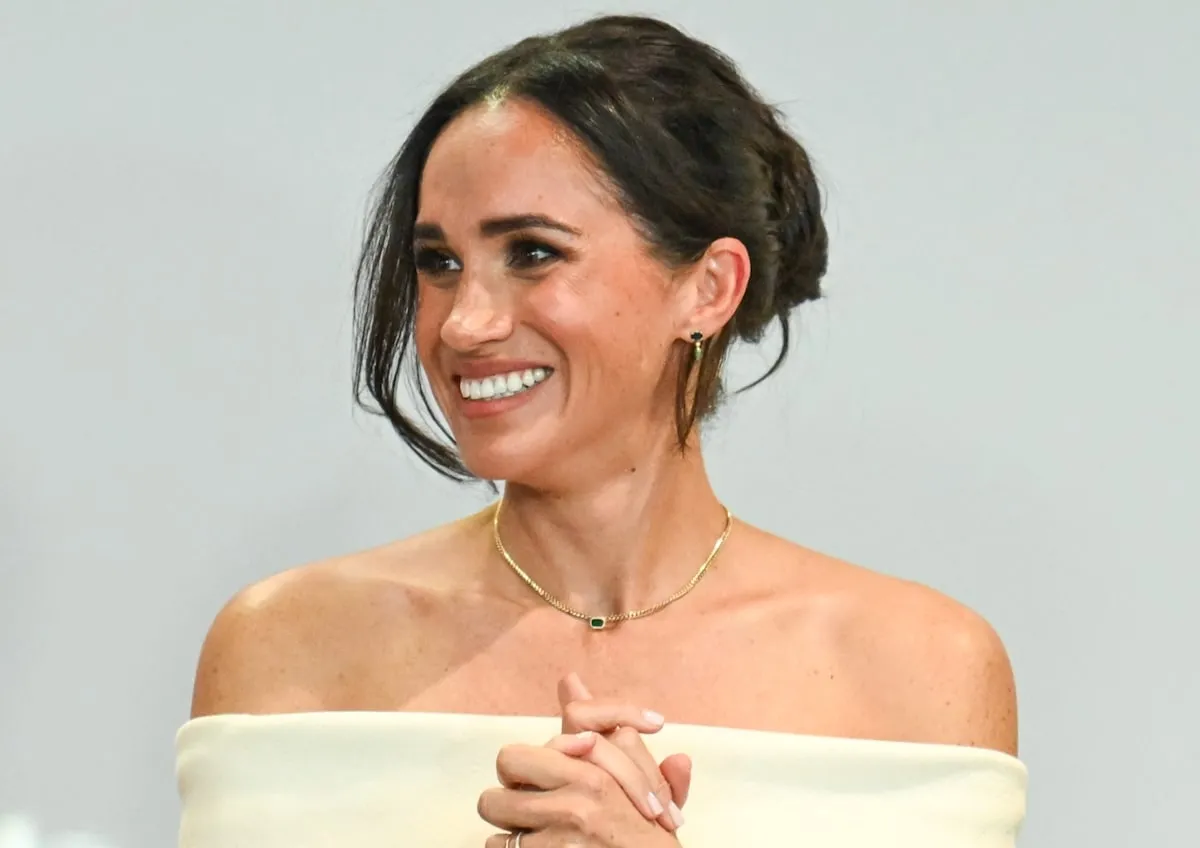 Wearing an emerald choker, Meghan, Duchess of Sussex, speaks onstage at The Archewell Foundation Parents’ Summit 2023