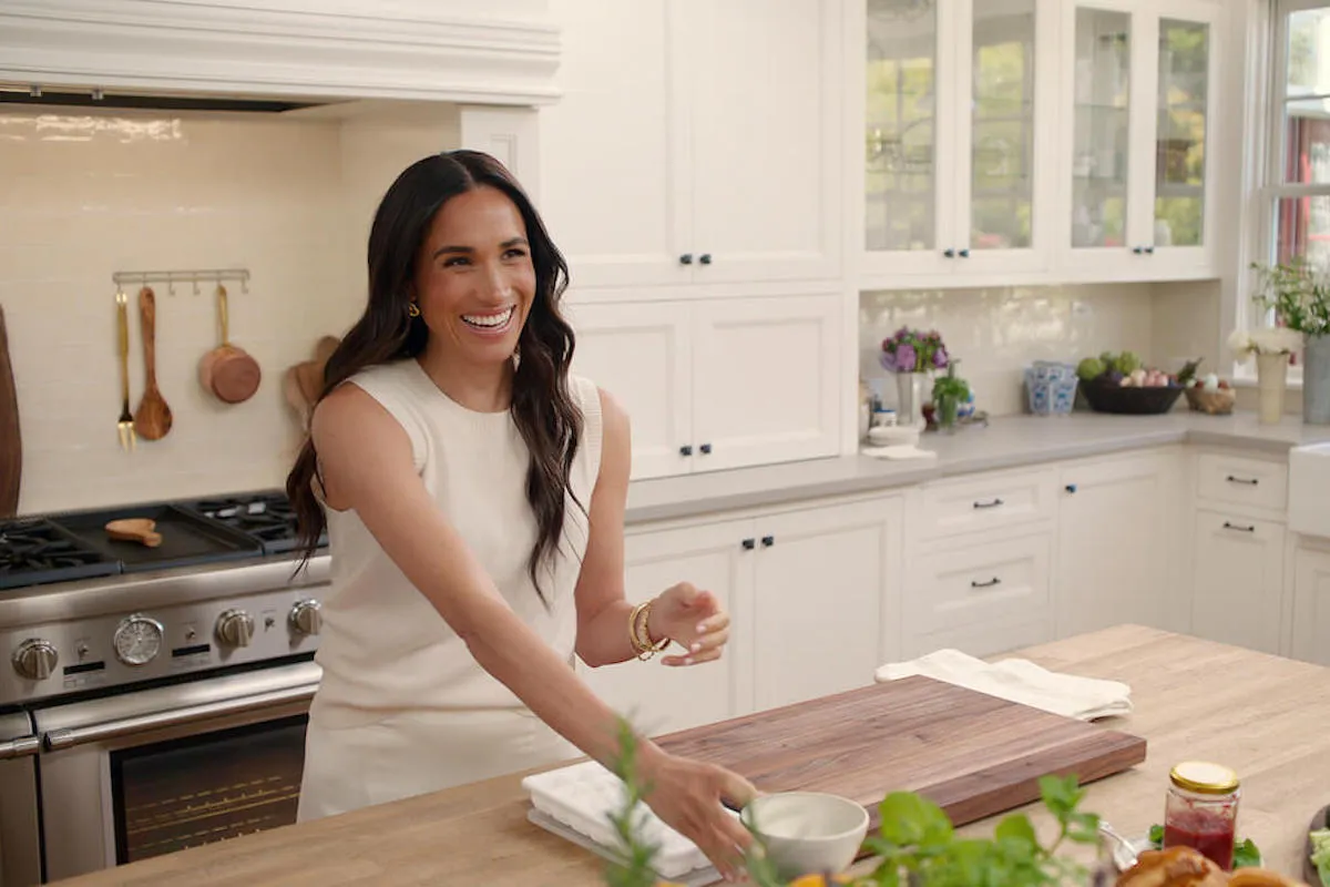 Meghan Markle in a photo still standing at a kitchen counter from 'With Love, Meghan'