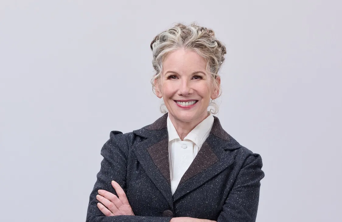 Melissa Gilbert with gray hair and her arms crossed in a promo shot for 'When Calls the Heart' Season 12