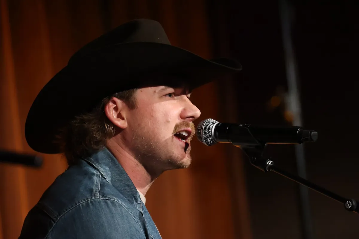 Morgan Wallen wearing a cowboy hat and singing into a microphone