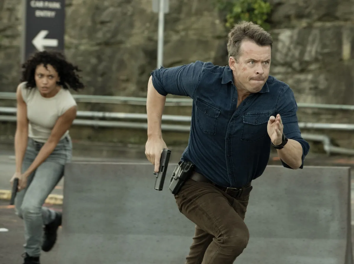 Mackey and JD running with guns drawn in 'NCIS: Sydney' Season 2 premeire