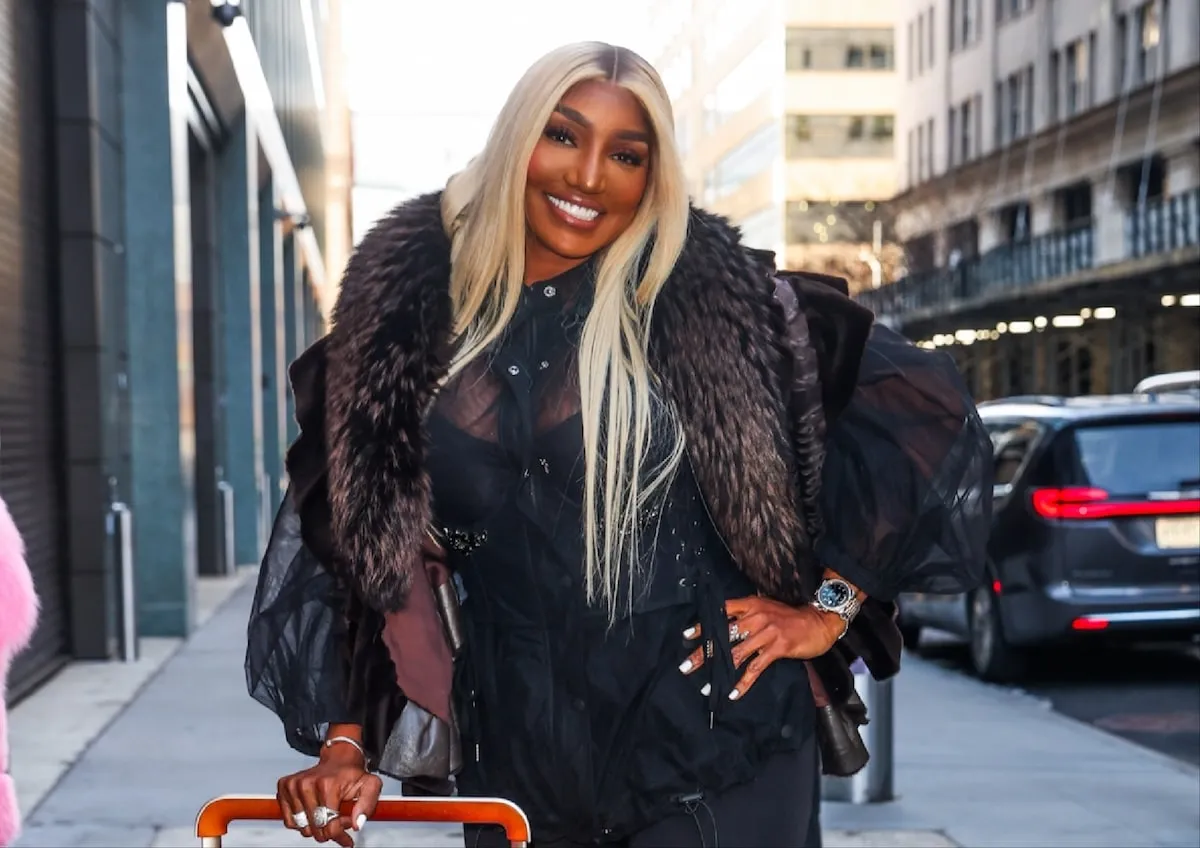 TV personality NeNe Leakes wears a black outfit and poses on a sidewalk in NYC