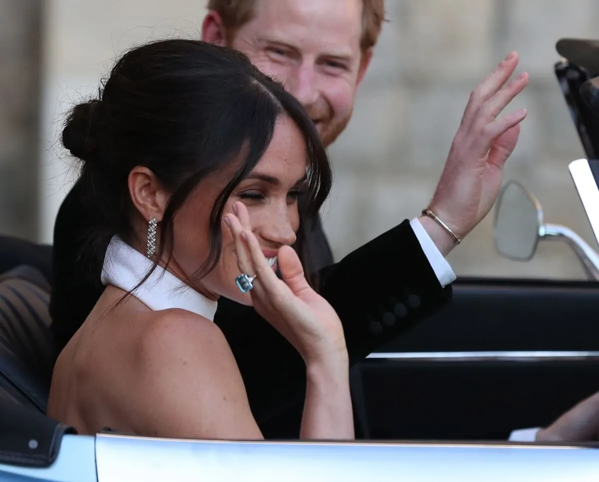 Prince Harry and Meghan Markle wave as they leave Windsor Castle after their wedding to attend an evening reception at Frogmore House