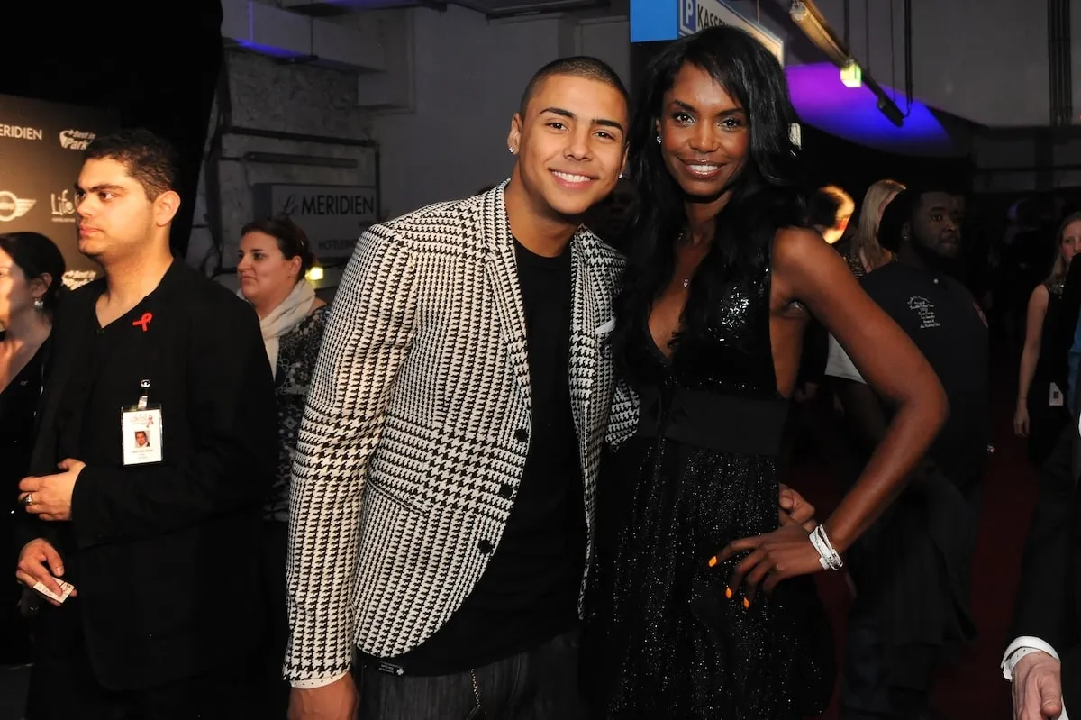 Wearing a checkered blazer, Quincy Brown smiles with his mom, Kim Porter, in 2012