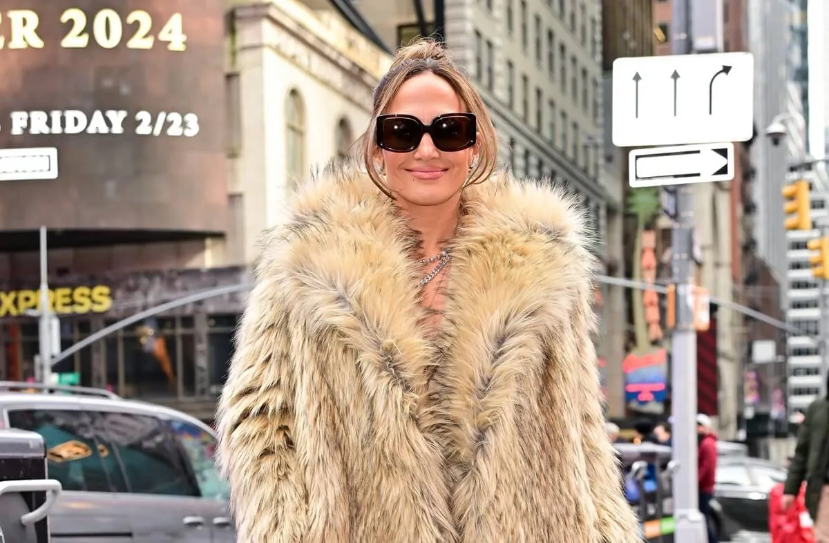 Jennifer Lopez posing in a tan fur coat at Times Square.