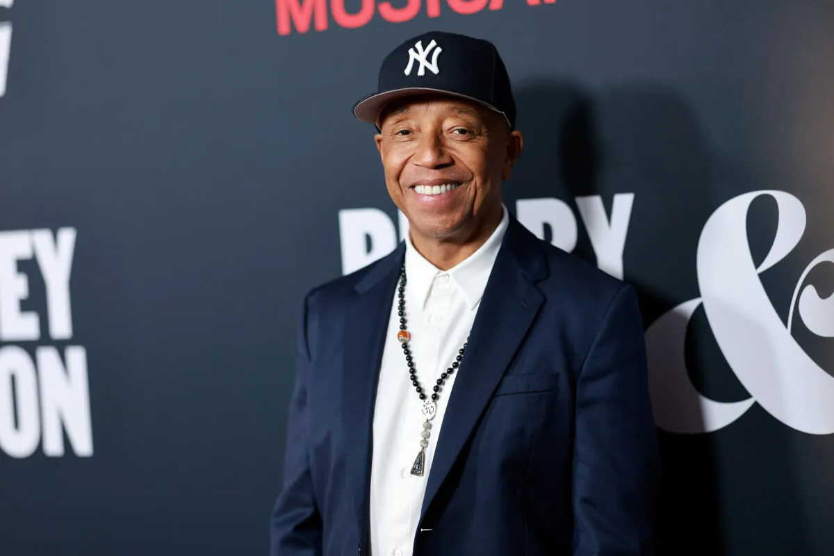 Russell Simmons wears a suit and a Yankees hat.