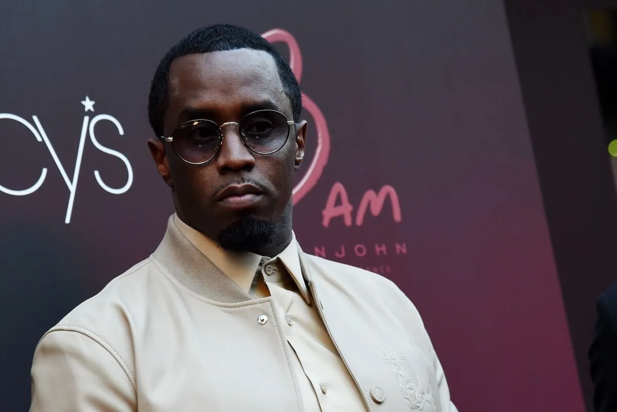 Sean 'Diddy' Combs wears a tan jacket and sunglasses.