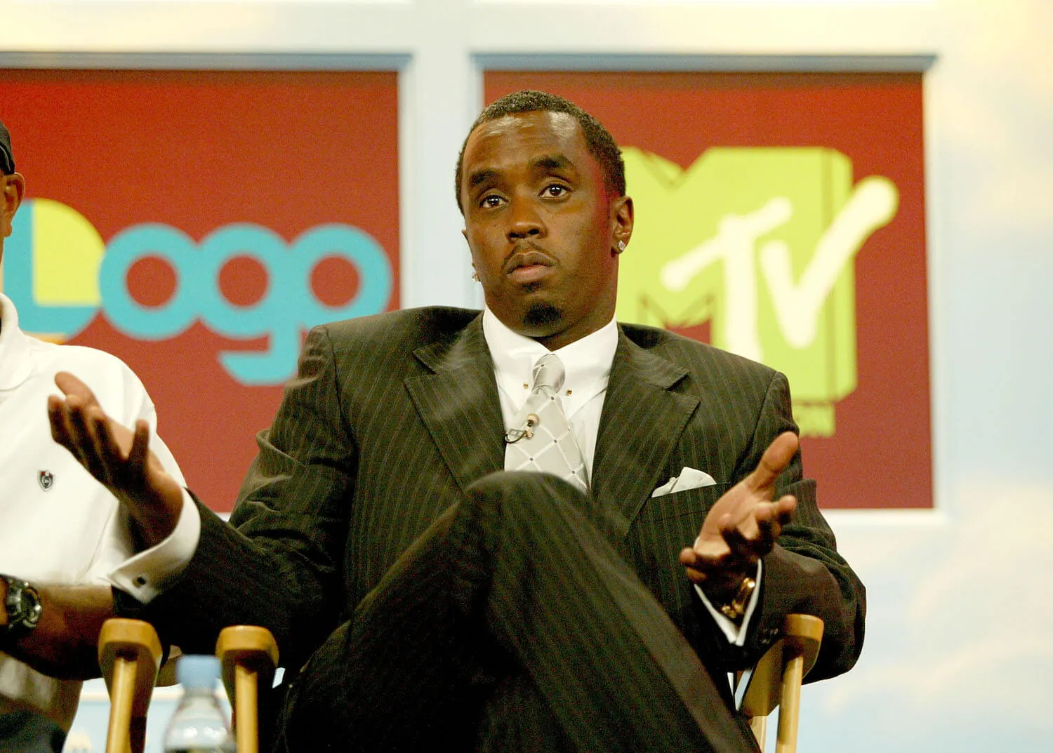 Sean 'Diddy' Combs sitting cross-legged in a chair and shrugging in 2005