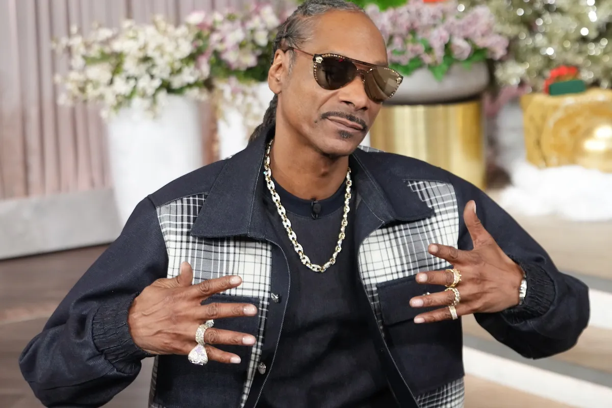 Snoop Dogg where a black jacket and sunglasses