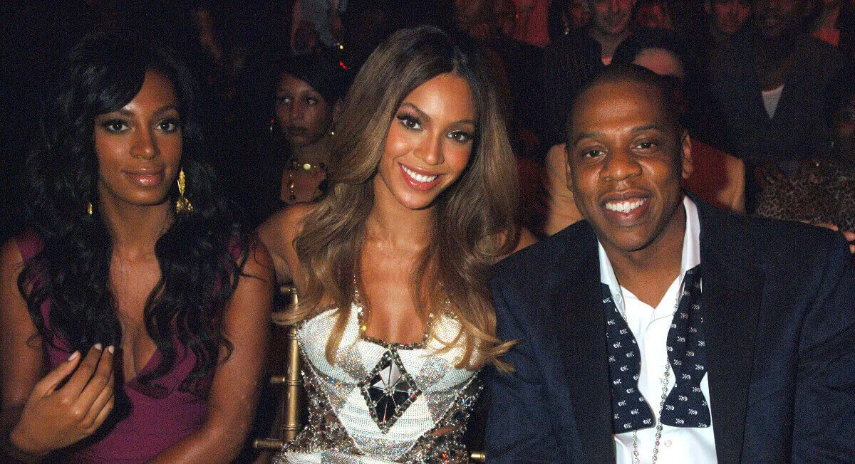 Solange, Beyonce, and Jay-Z sit together at an awards show.