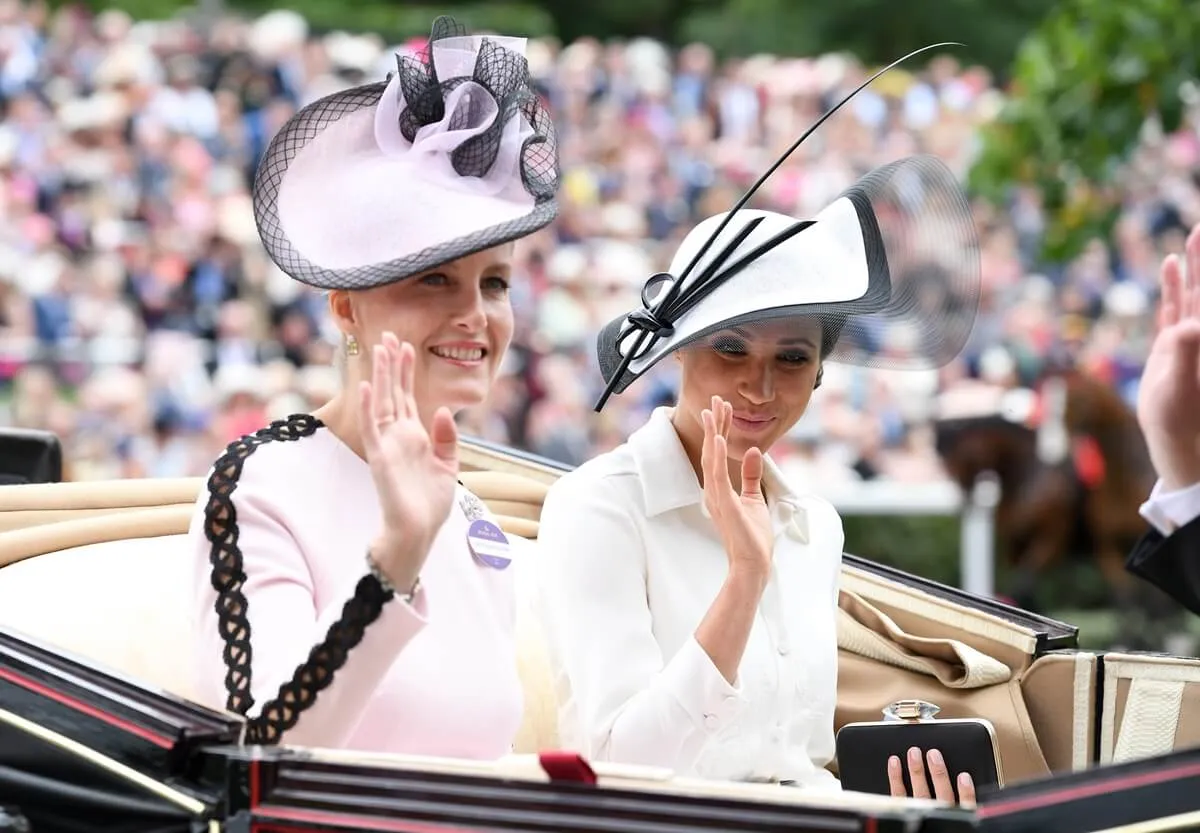 Sophie, Duchess of Edinburgh and Meghan Markle wave as they arrive to attend Royal Ascot Day 1 at Ascot Racecourse