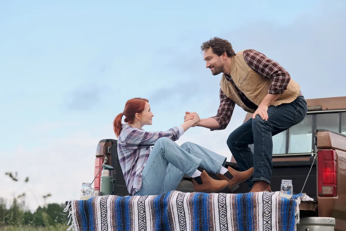 Man and woman in the back of a pickup truck in the Hallmark Channel movie 'The Wish Swap'