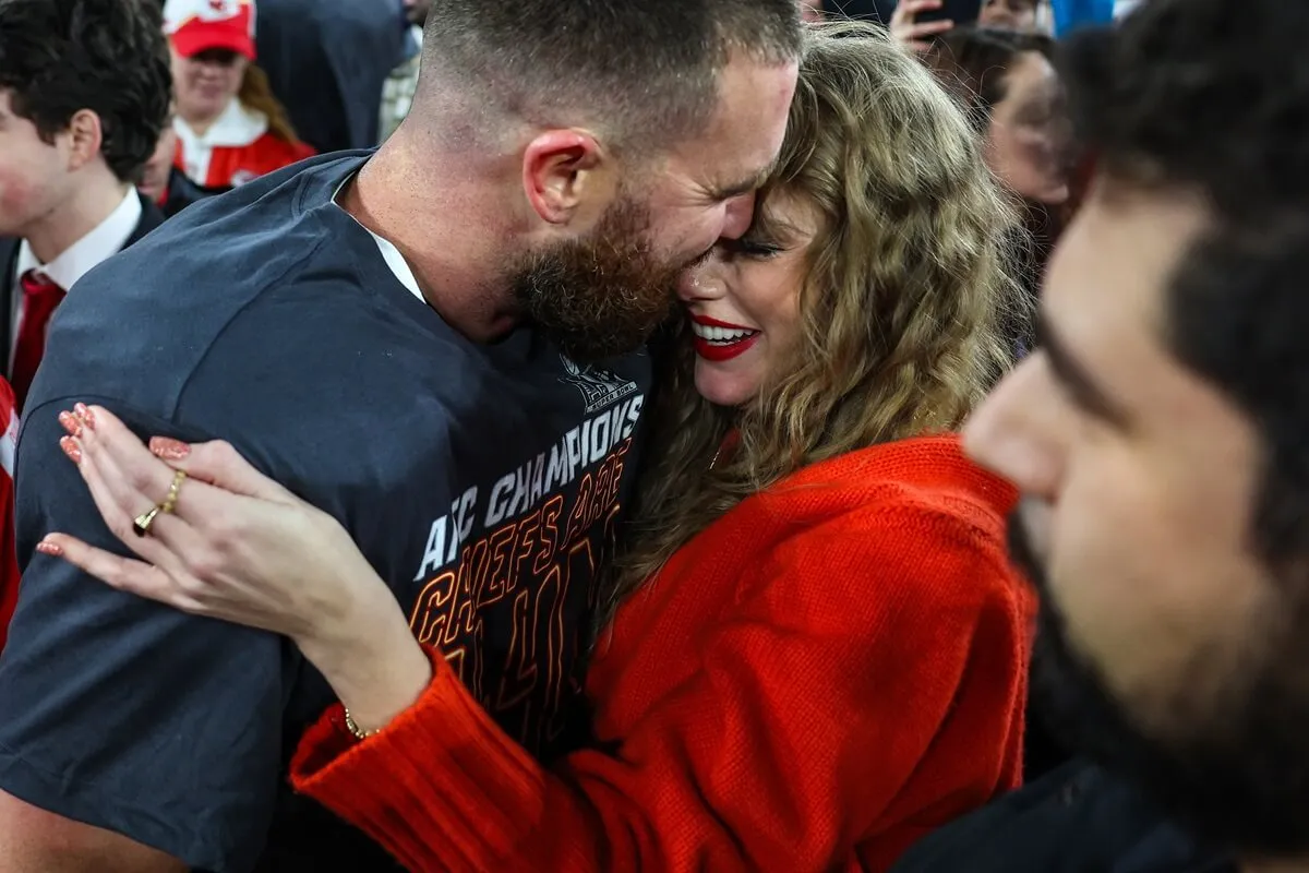 Travis Kelce celebrates on the field with Taylor Swift after defeating the Baltimore Ravens