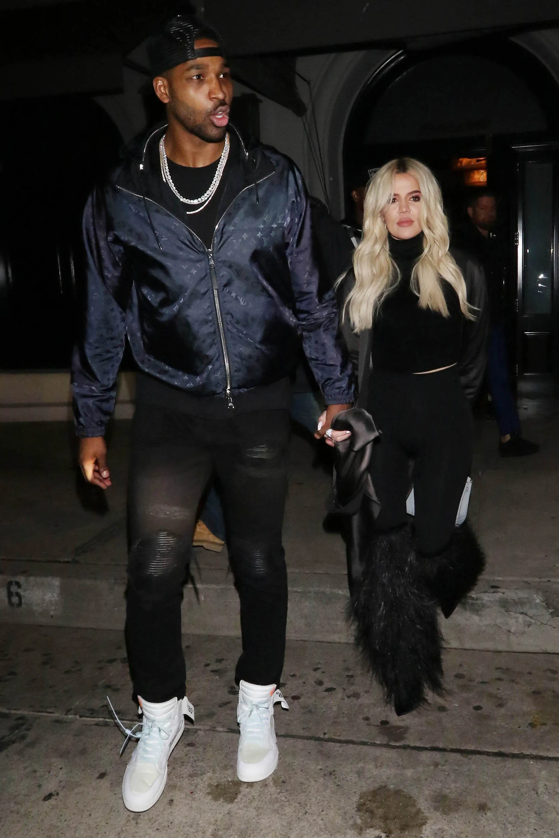 Khloé Kardashian and Tristan Thompson holding hands and walking together at night in Los Angeles