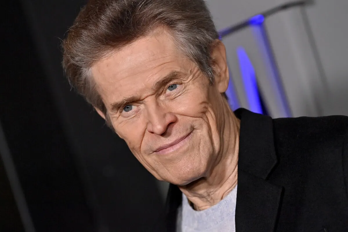 Willem Dafoe attends the Los Angeles Premiere of Focus Features' "Nosferatu" in a black blazer and grey shirt.