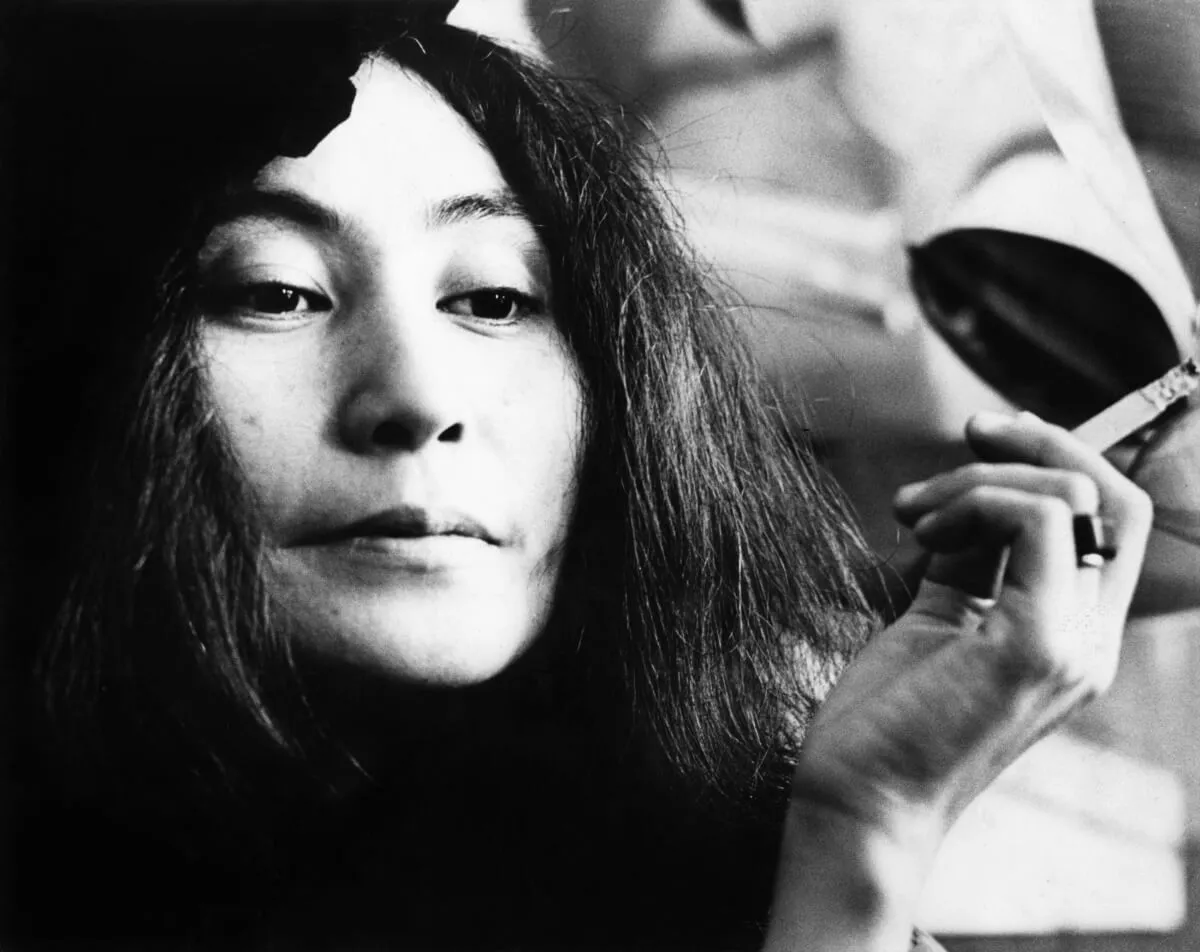 A black and white picture of Yoko Ono smoking a cigarette.