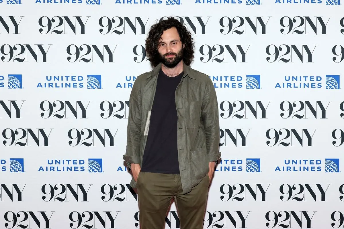 Penn Badgley attends Vibe Check: Saeed Jones, Sam Sanders, Zach Stafford In Conversation With Penn Badgley at 92NY while wearing a green jacket, black shirt and brown pants.