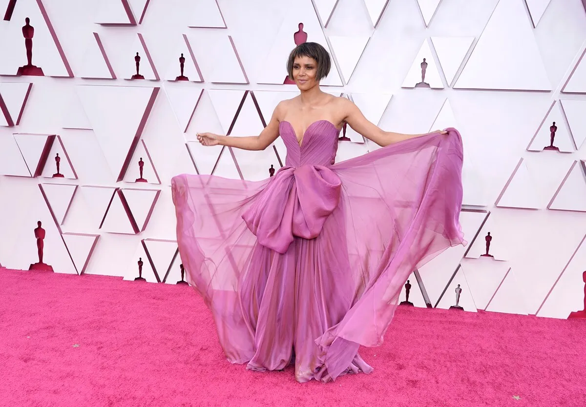 Halle Berry posing at the Oscars while wearing a pink dress.