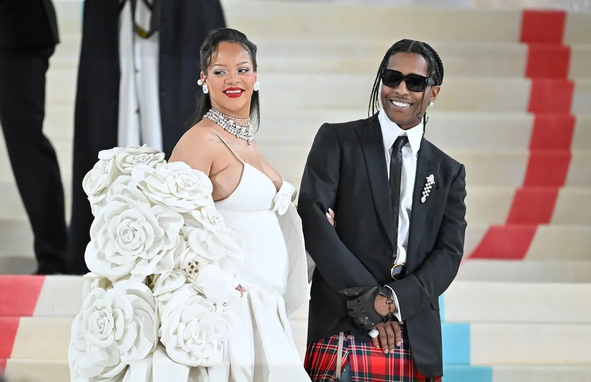 Wearing a white gown and black tuxedo respectively, Rihanna and A$AP Rocky smile for cameras at the 2023 Met Gala