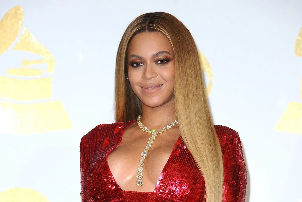 Beyonce posing in a red dress at the 59th GRAMMY Awards at Staples Center.