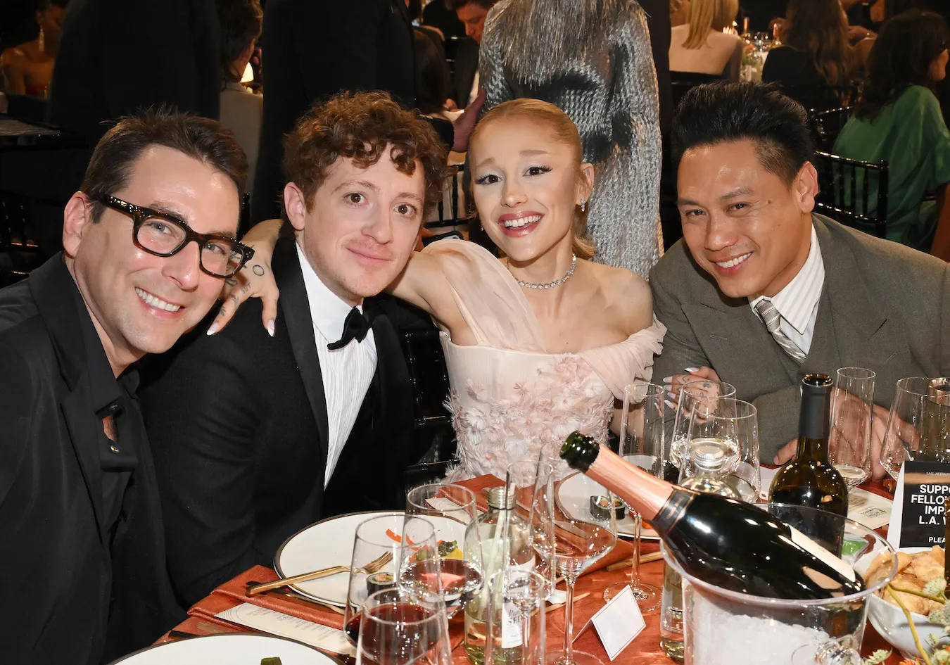 Ethan Slater, Ariana Grande, and Jon M. Chu posing together at a table at the SAG Awards