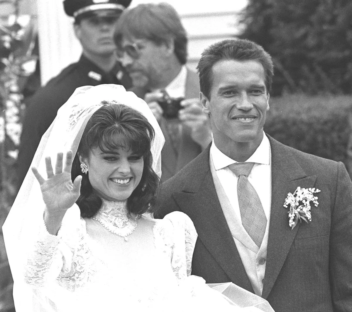 Wearing a white dress, Maria Shriver waves on her wedding day to Arnold Schwarzenegger