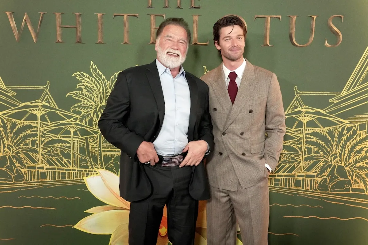 Standing together arm in arm, Arnold Schwarzenegger and Patrick Schwarzenegger take photos at the world premiere of 'The White Lotus' Season 3