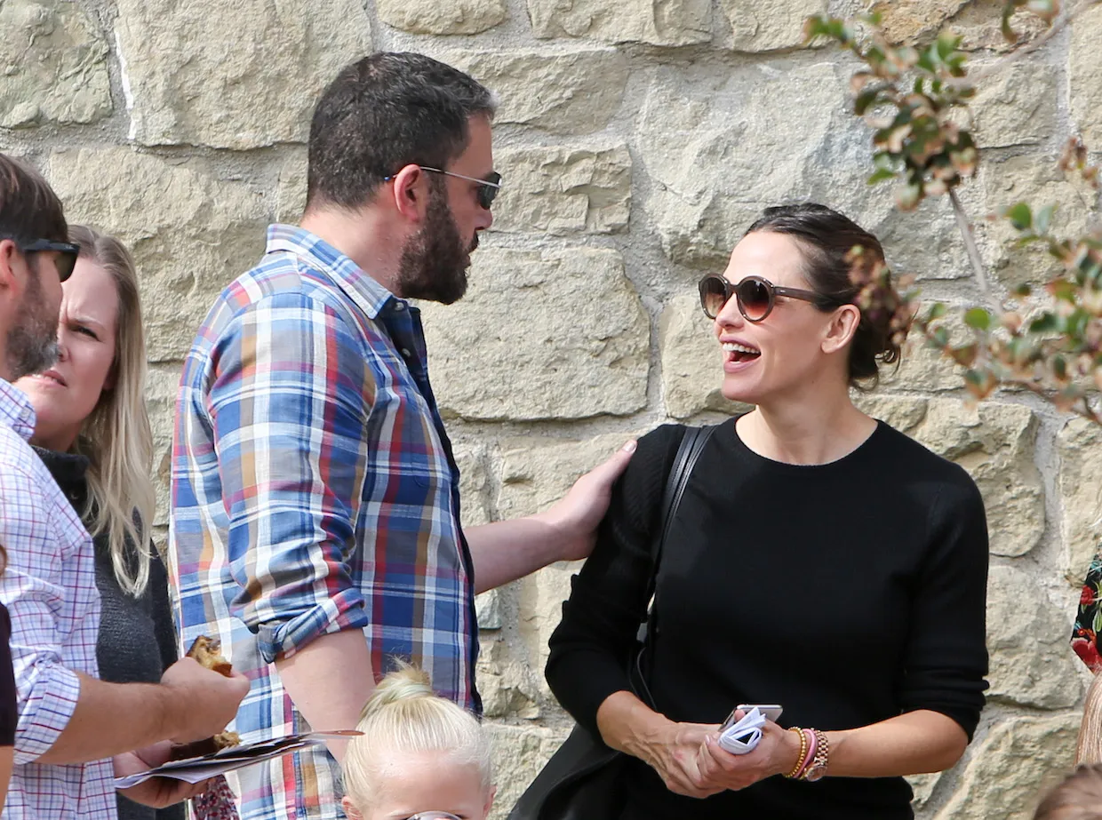 Ben Affleck with his hand on Jennifer Garner's shoulder as she looks at him with her mouth open