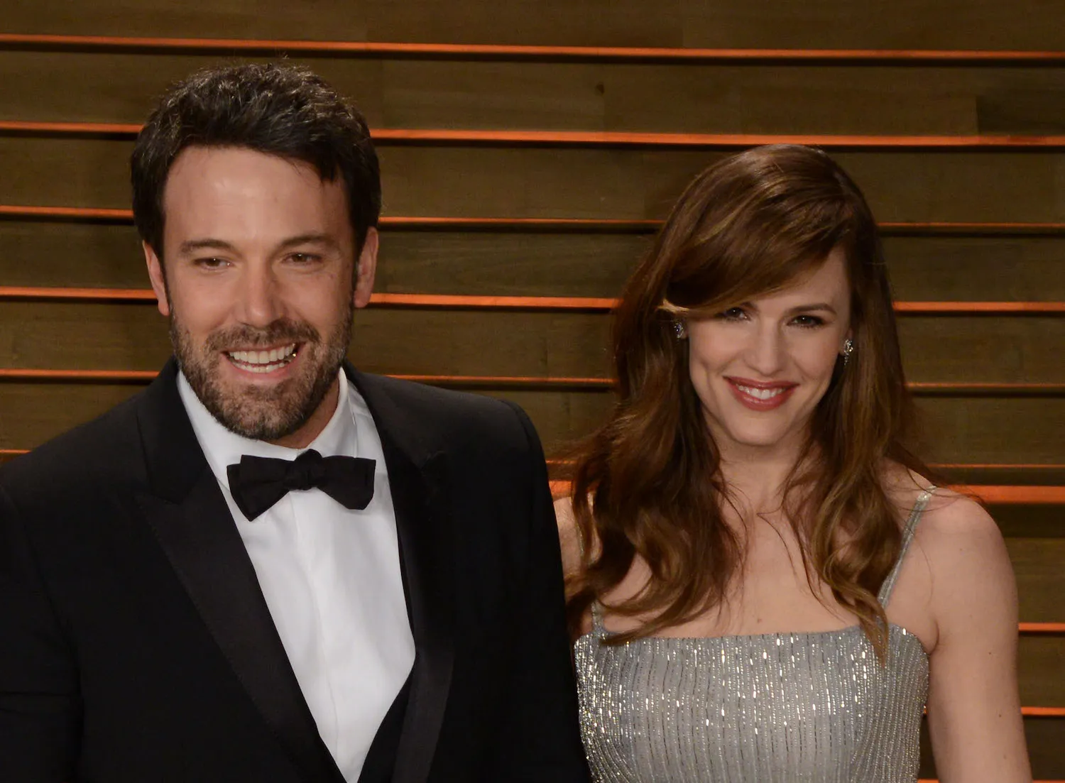 Ben Affleck and Jennifer Garner in formal clothing and smiling next to each other in 2014