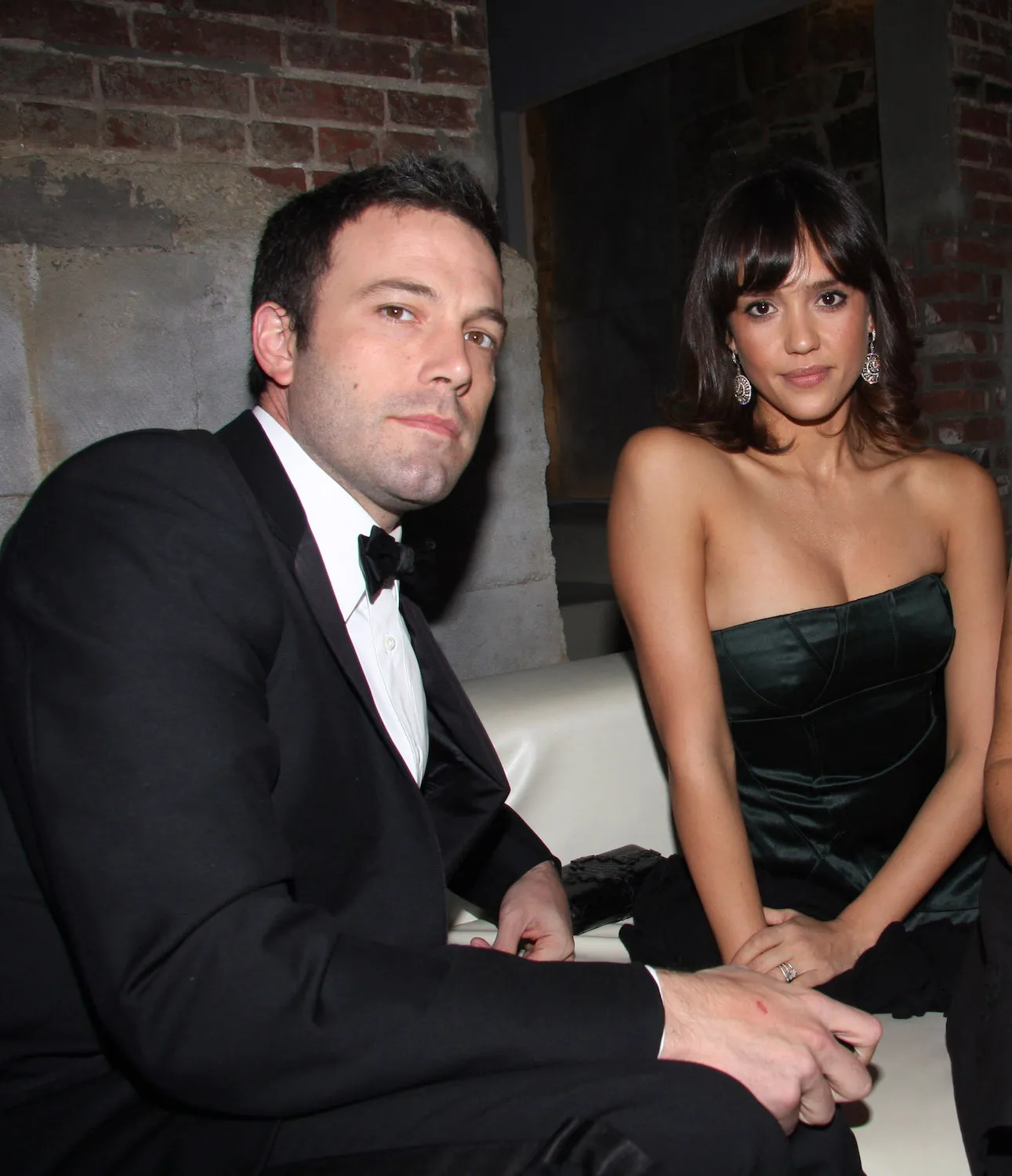 Ben Affleck sitting in a suit leaning back toward Jessica Alba, who's sitting behind him and wearing a strapless black gown