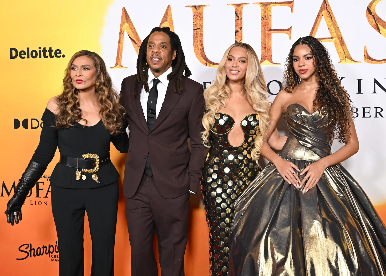 Tina Knowles, Jay-Z, Beyoncé, and Blue Ivy Carter standing together and smiling at the 'Mufasa' premiere.