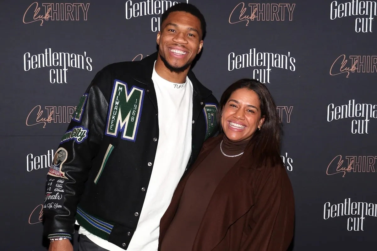 Mariah and Giannis Antetokounmpo smile together at a bourbon party, with Mariah looking visibly pregnant