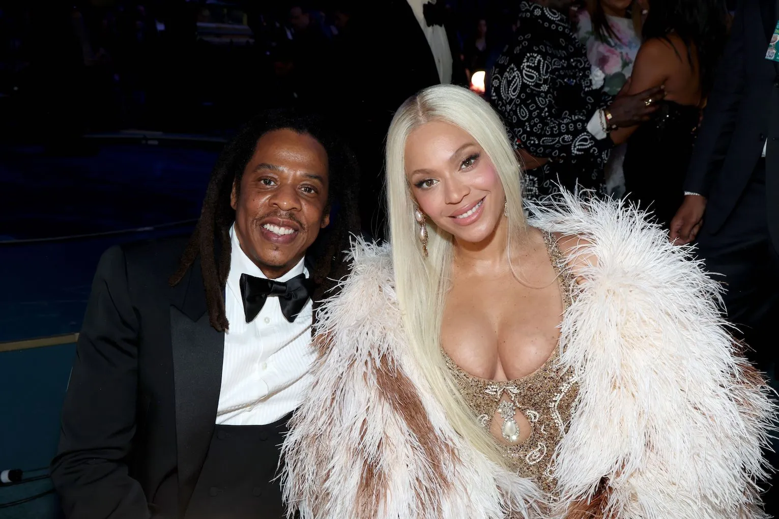 Jay-Z and Beyoncé sitting at the Grammy Awards in February 2025. Jay-Z is wearing a suit and Beyoncé is wearing a gold dress and feather jacket.