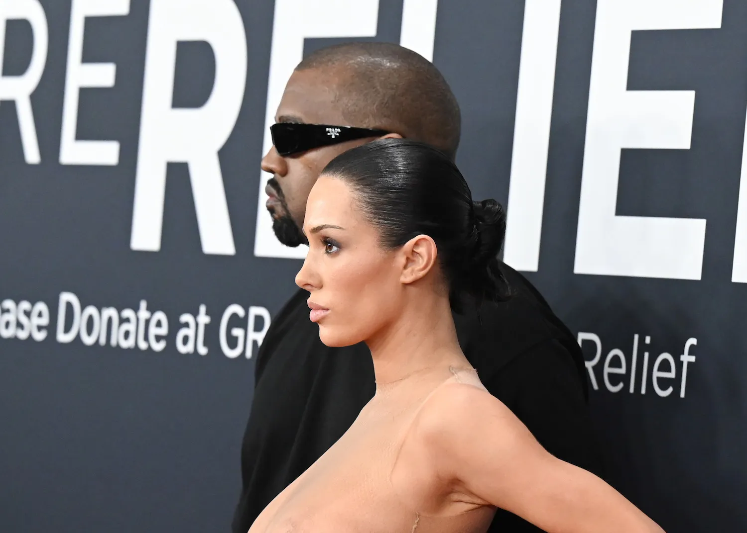 A side view of Bianca Censori from the neck-up nearly nude at the Grammys next to Kanye West