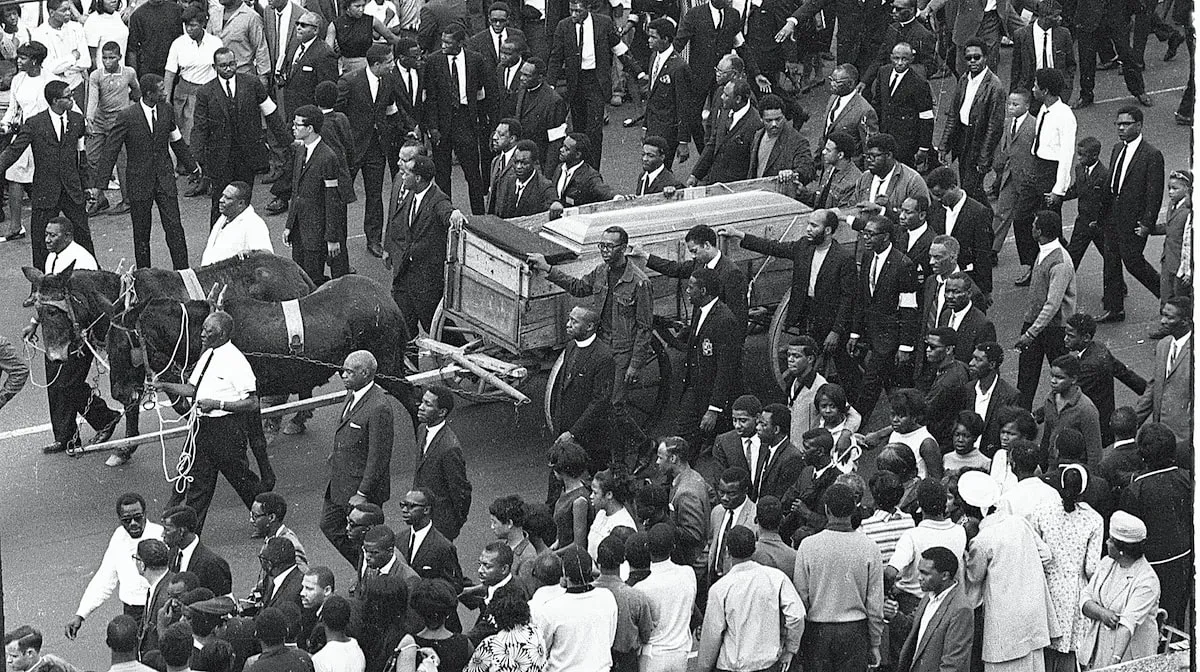 A high-angle view of the casket of assassinated Civil Rights leader Dr. Martin Luther King Jr. on a mule-drawn cart during a massive funeral procession through the streets of King's hometown, Atlanta