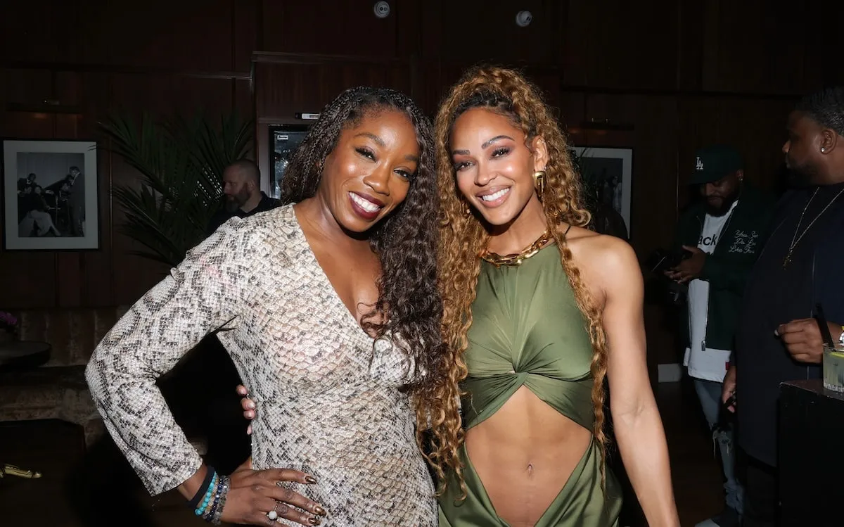 Estelle and Meagan Good hold each other and smile at an Amazon Prime party