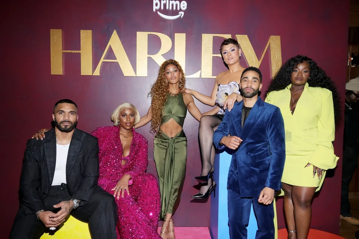 The cast of Harlem poses in front of the logo at the Amazon Prime premiere party