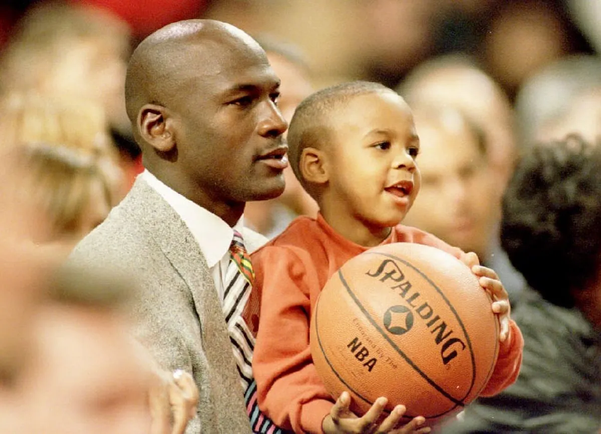 A retired Chicago Bulls basketball star Michael Jordan watches a Bulls game with his son Marcus Jordan in 1993