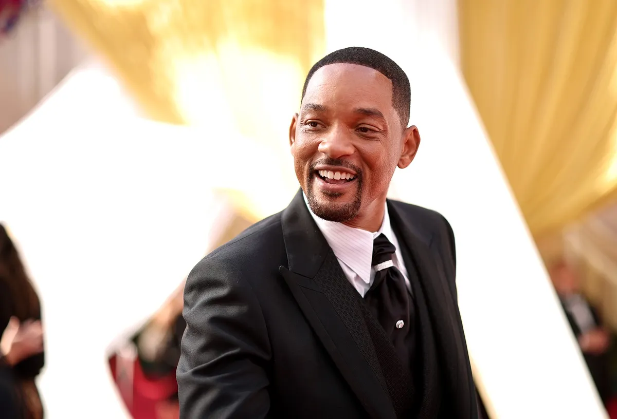 Will Smith smiling in a suit at the 94th Annual Academy Awards at Hollywood and Highland.