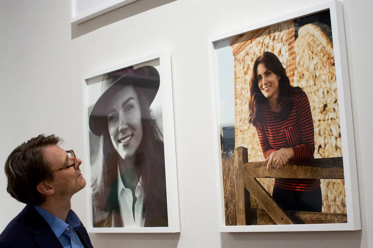 A gallery associate looks at photos of Kate Middleton's 2016 British Vogue cover shoot.