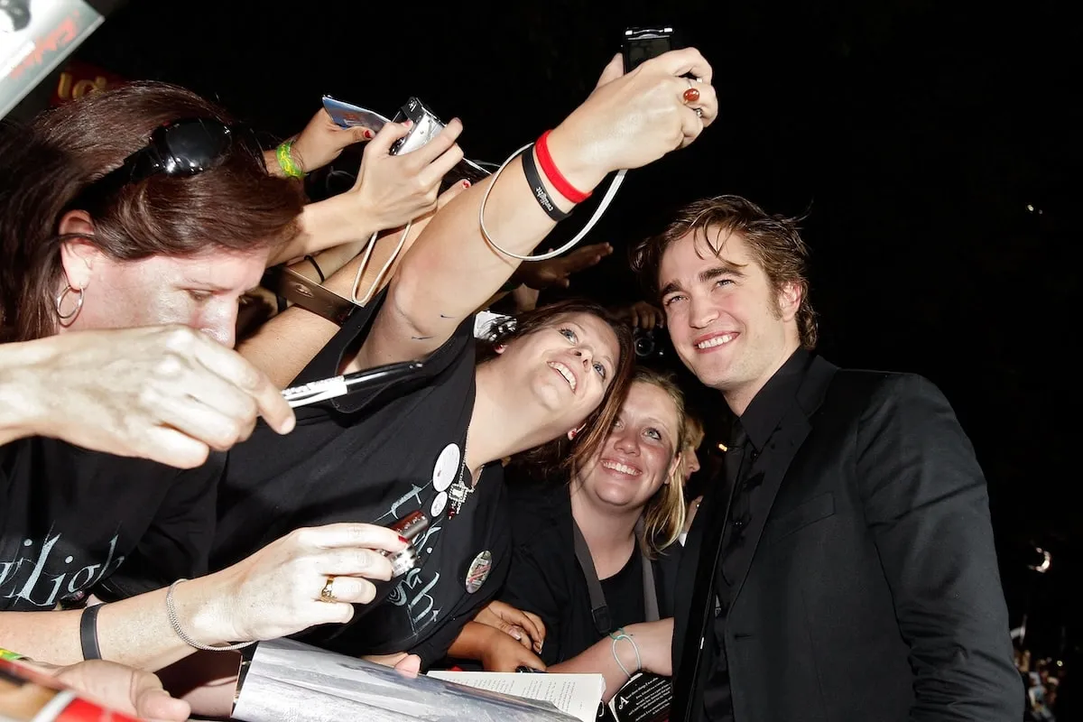 Actor Robert Pattinson smiles with fans at the premiere of "Twilight" in 2008