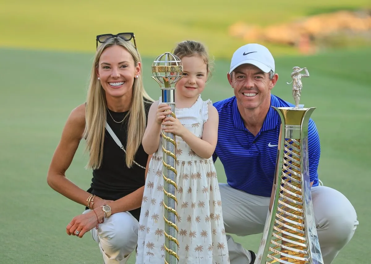 Rory McIlroy poses with the Race to Dubai and The DP World Tour Championship trophies with his wife, Erica Stoll, and their daughter, Poppy