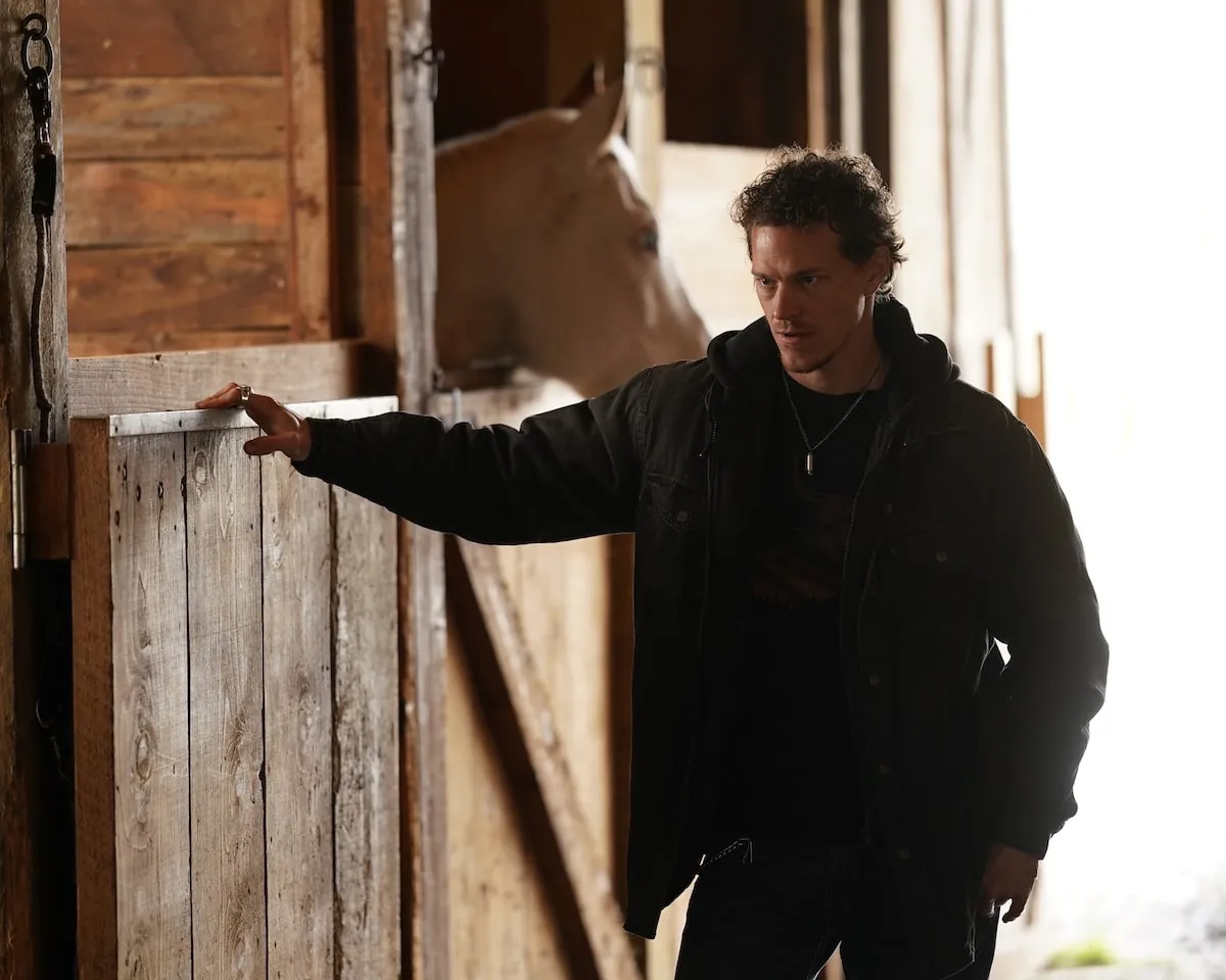 Actor Ryan Dorsey stands in a horse barn while filming 'Big Sky' in 2021