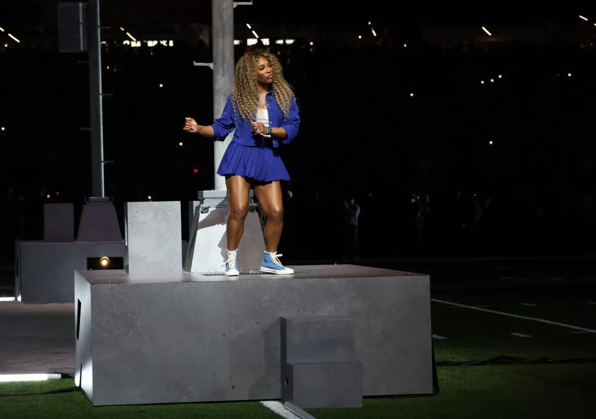 Serena Williams wears a blue skirt and jacket and dances on a platform during the Super Bowl halftime show.