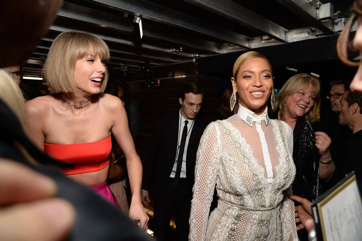 Taylor Swift wears a red top and pink skirt. Beyonce wears a white dress.