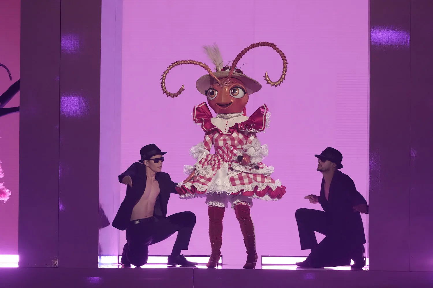 'The Masked Singer' Season 13 contestant Ant on stage with two others against a light purple background